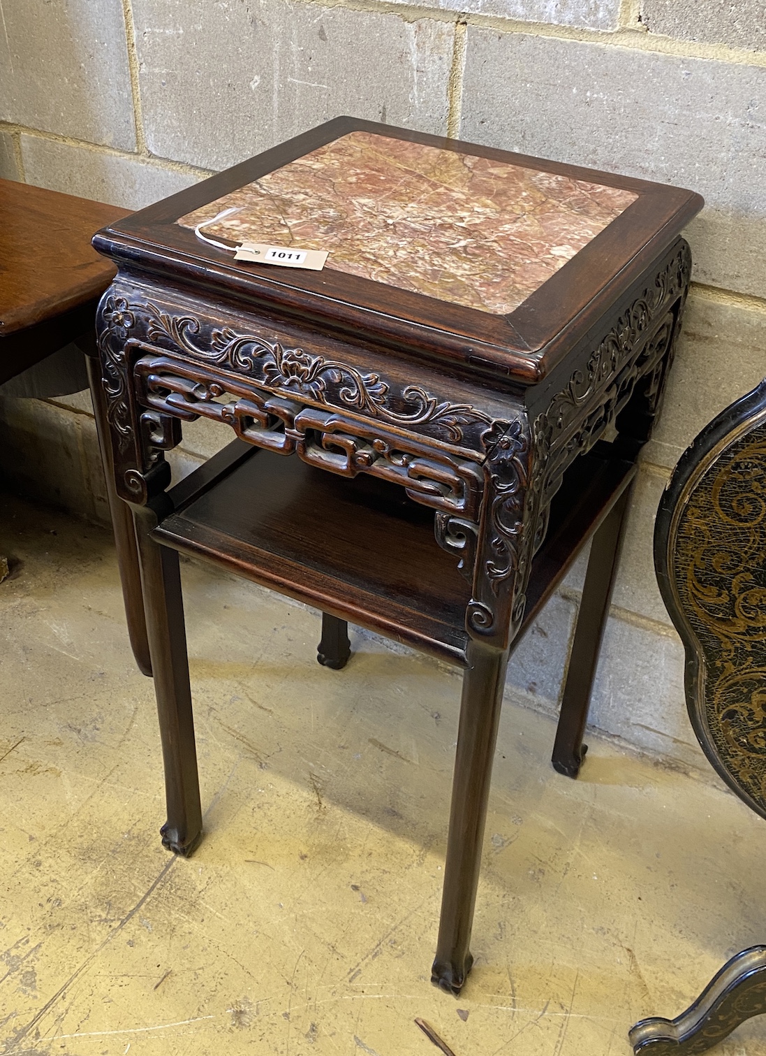 A Chinese carved hardwood rouge marble topped two tier vase stand, width 41cm, height 81cm